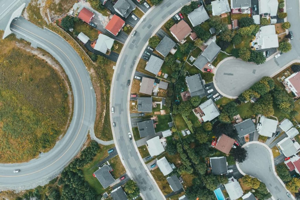 Aerial view of a residential neighborhood with curved streets, homes, and yards, representing local real estate and property ownership.